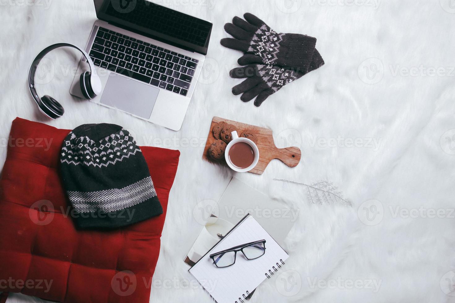 Creative flat lay composition of winter gloves, beanie and work accessories for winter background photo