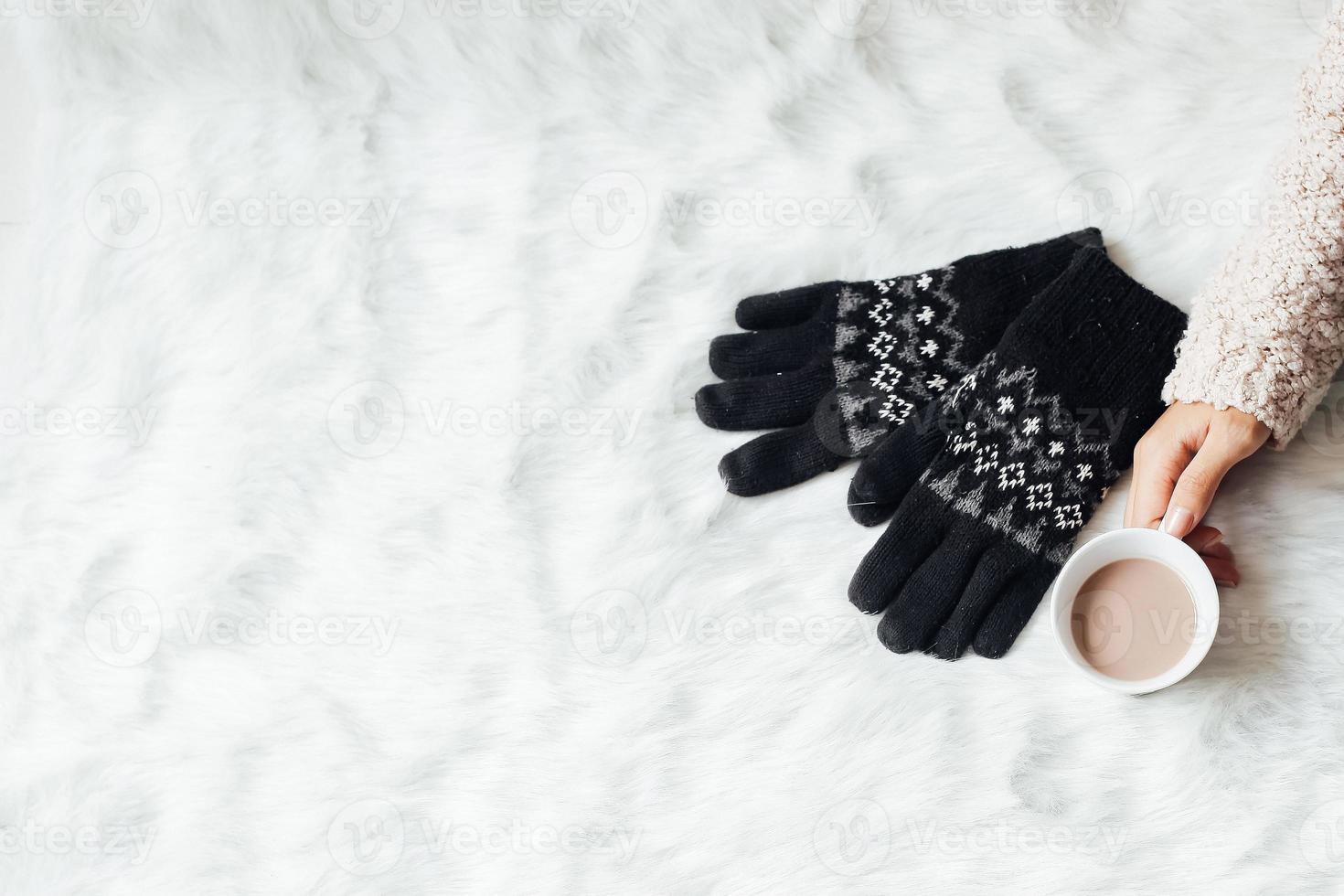 vista superior de las manos femeninas sosteniendo un vaso lleno de chocolate caliente y guantes con espacio de copia para el concepto de fondo de invierno foto