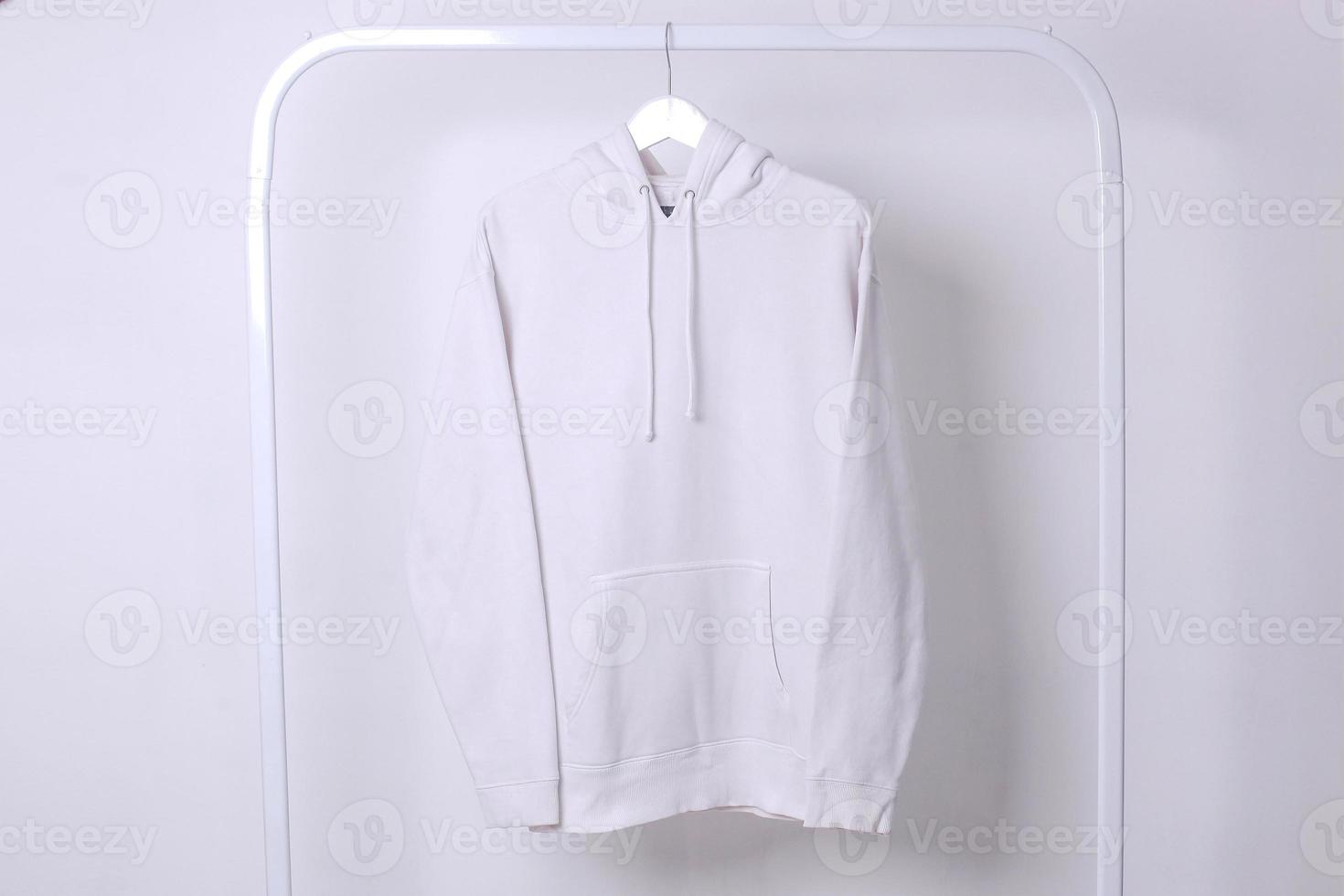 Mockup of white hoodie hanging on iron hanger isolated on white background photo