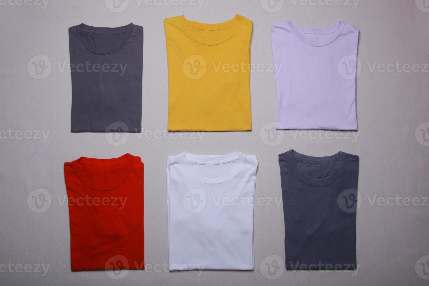 Collection of colorful folded t-shirt mockups on gray background. Flat tee lay template photo