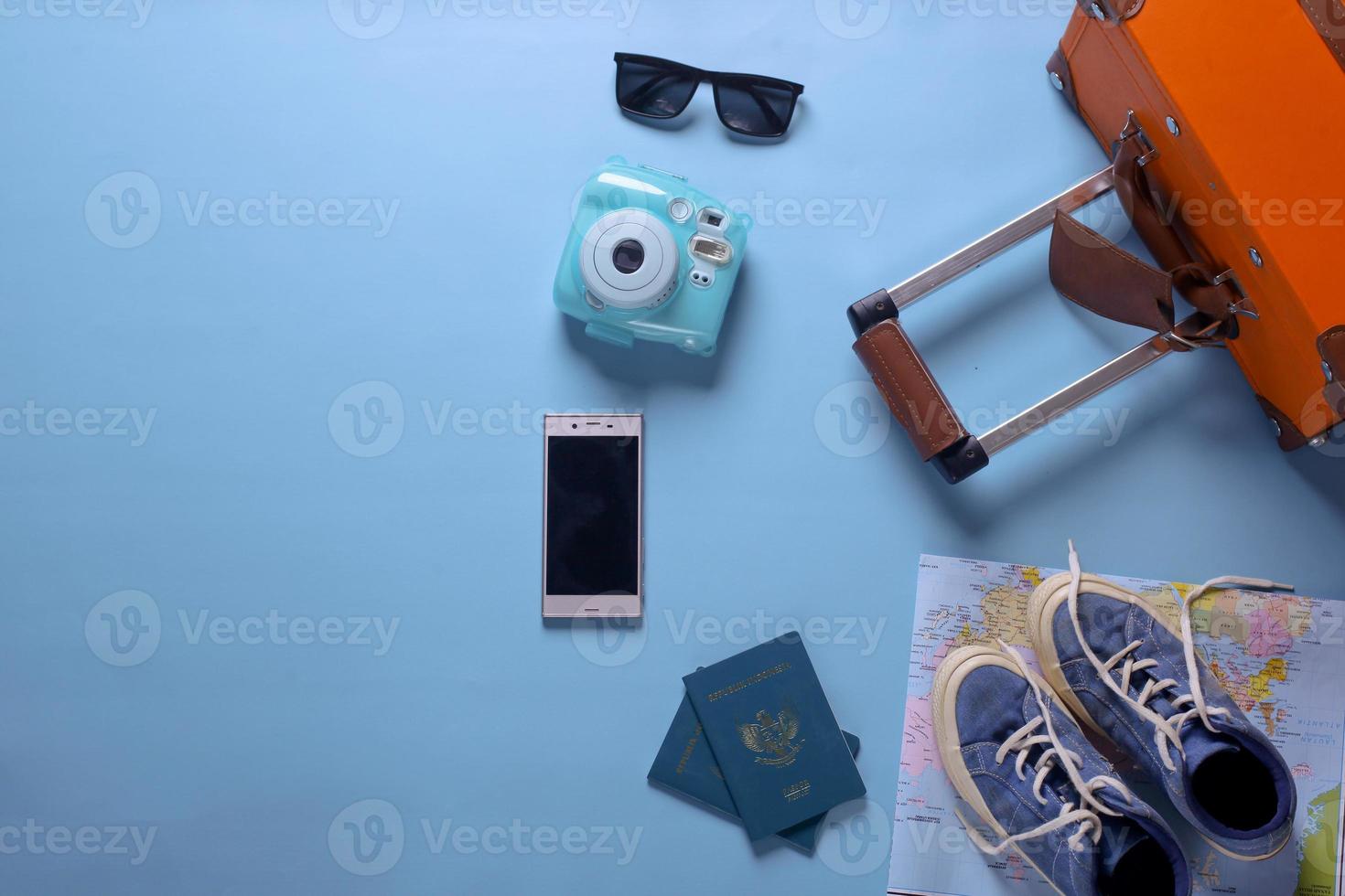 Flat lay of travel or holiday concept with copy space on blue background photo