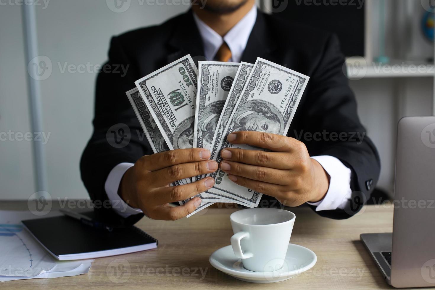 Success businessman counting a hundred dollar bills on office desk photo