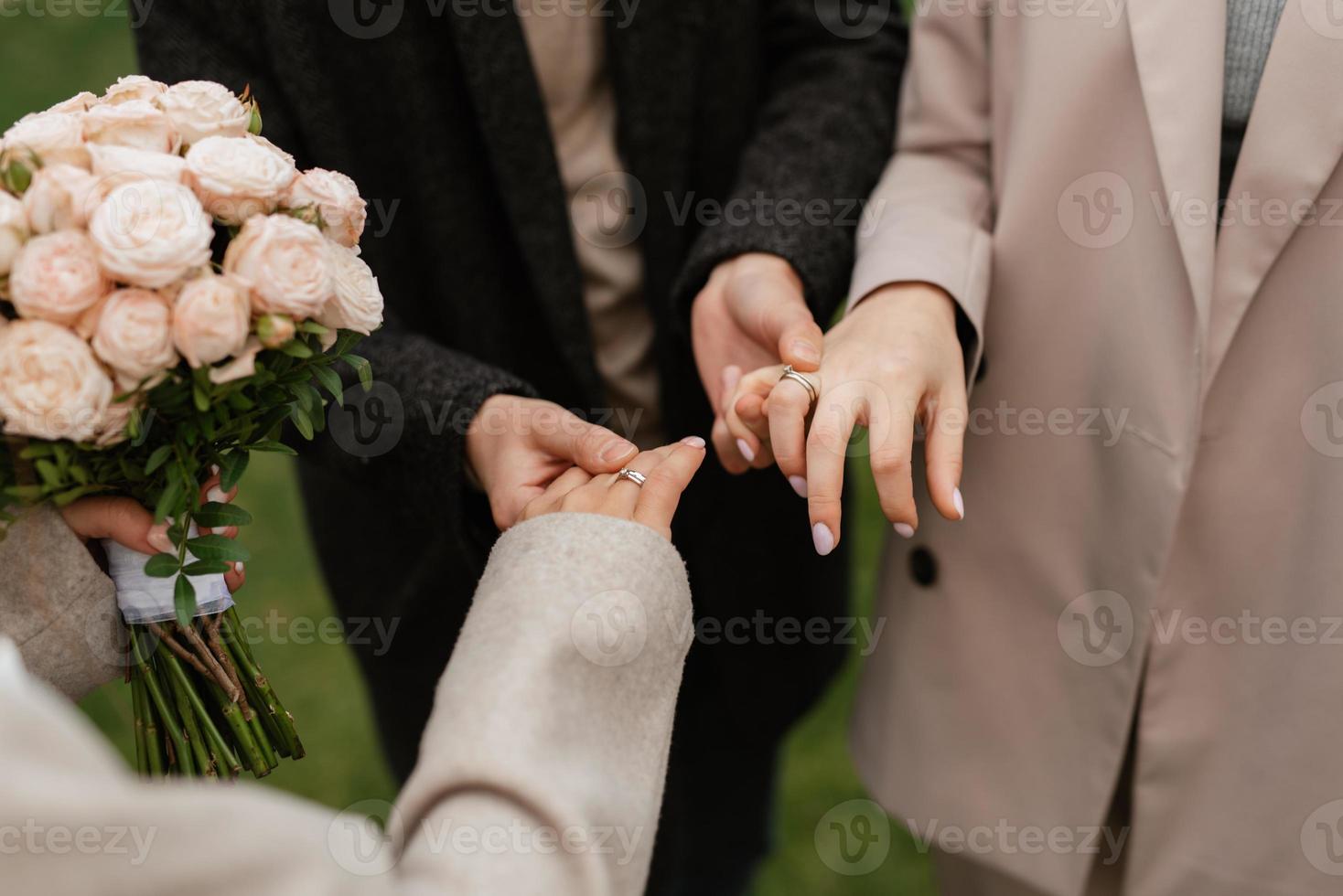 the bride and groom tenderly hold hands photo