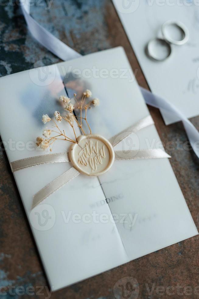 anillos de boda de oro con una invitación de boda foto