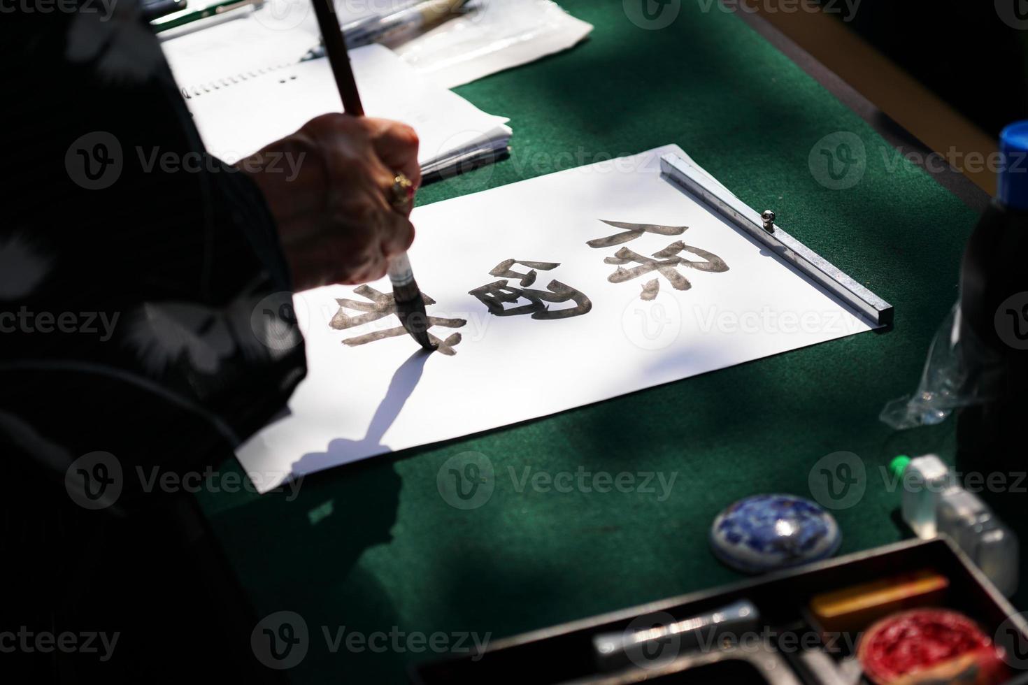 japanese calligraphy with ink brush on paper photo