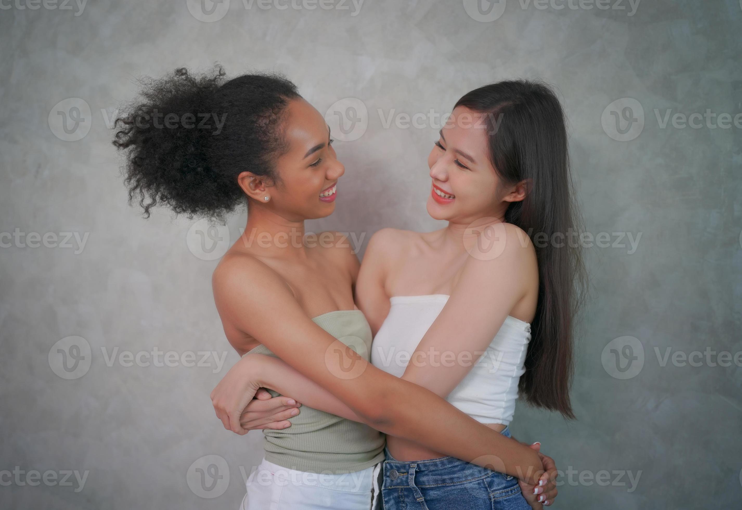 Beauty picture of young gorgeous happy optimistic beautiful blonde and brunette women posing naked isolated over beige wall background talking with each other gossiping