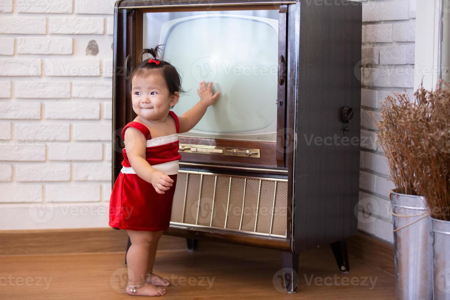 Little baby girl in red costume on Christmas day. photo