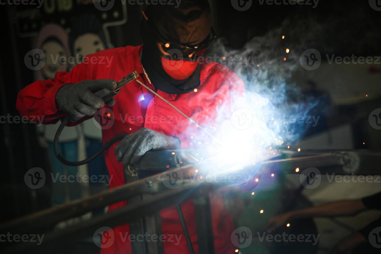 soldador utilizó piedra de moler sobre acero en fábrica con chispas, proceso de soldadura en el taller industrial, manos con instrumento en marco. foto