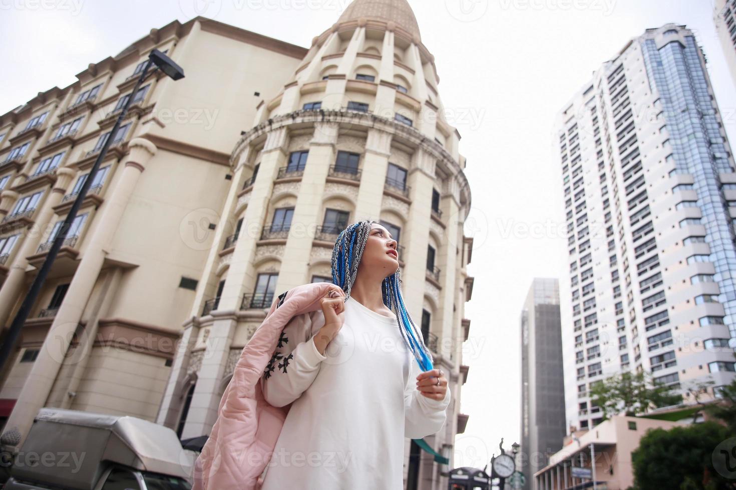 Portrait of Young girl with blue hair, teenage standing on street as urban life. photo