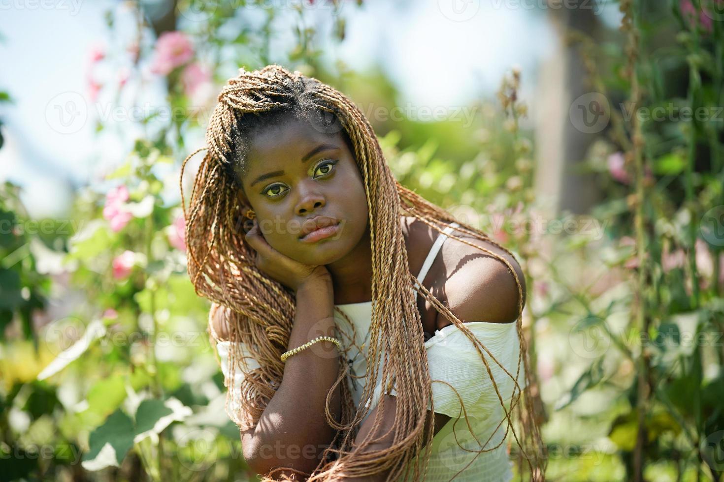 retrato de una joven mujer de piel negra con pose de peinado afro al aire libre. foto