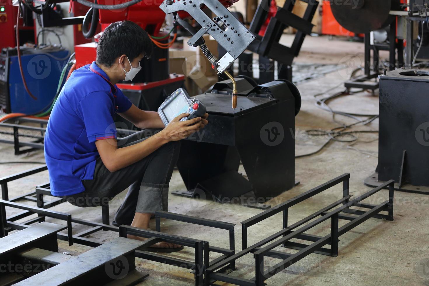 Industrial engineer or worker wearing a helmet while standing in a heavy industrial factory. The Maintenance looking of working at industrial machinery and check security system setup in factory. photo