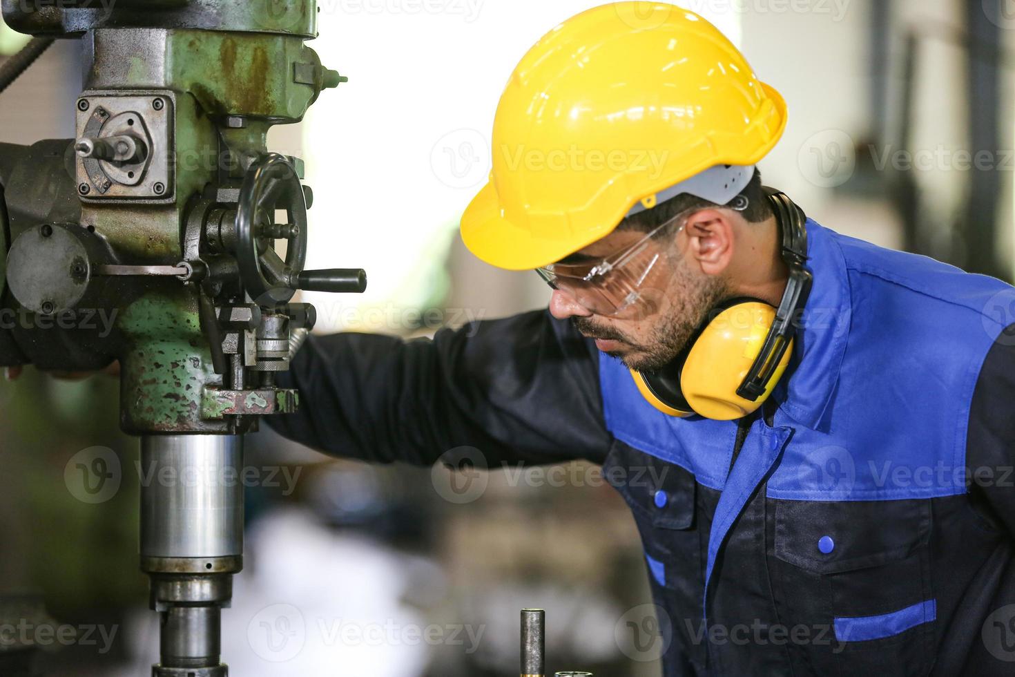 Professional industrial factory employee working with machine part, checking and testing industrial equipment and robot arms in large Electric electronics wire and cable manufacturing plant factory photo