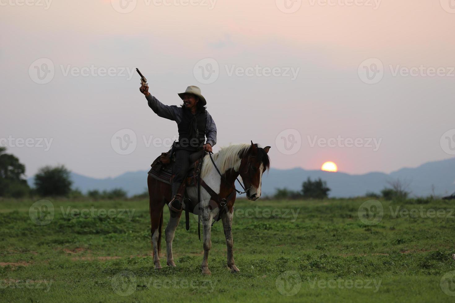 vaquero a caballo contra una hermosa puesta de sol, vaquero y caballo a primera luz, montaña, río y estilo de vida con fondo de luz natural foto