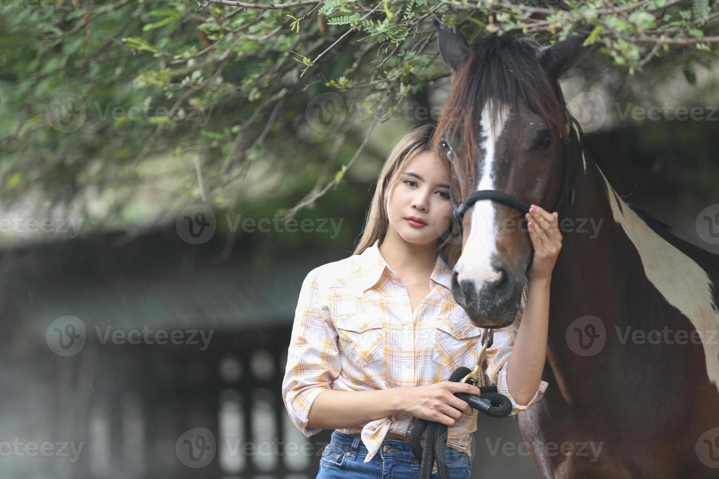 mujer joven con su caballo en la luz del atardecer. fotografía al aire libre con una modelo de moda. estado de ánimo de estilo de vida foto