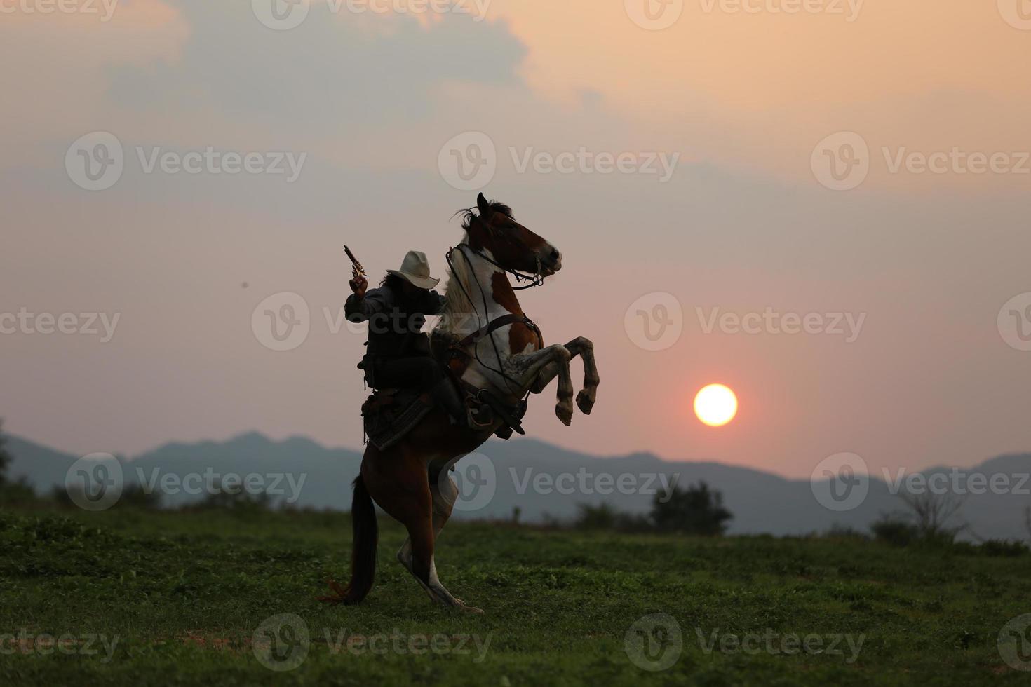 Silhouette Cowboy on horseback against a beautiful sunset, cowboy and horse at first light, mountain, river and lifestyle with natural light background photo