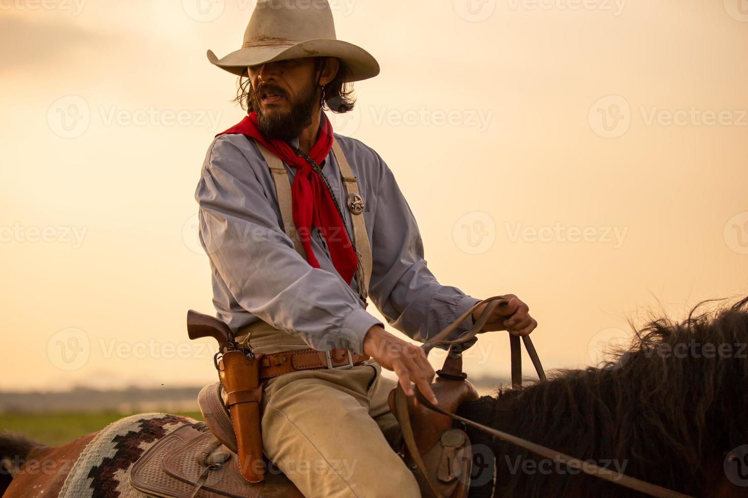 vaquero a caballo contra una hermosa puesta de sol, vaquero y caballo a primera luz, montaña, río y estilo de vida con fondo de luz natural foto