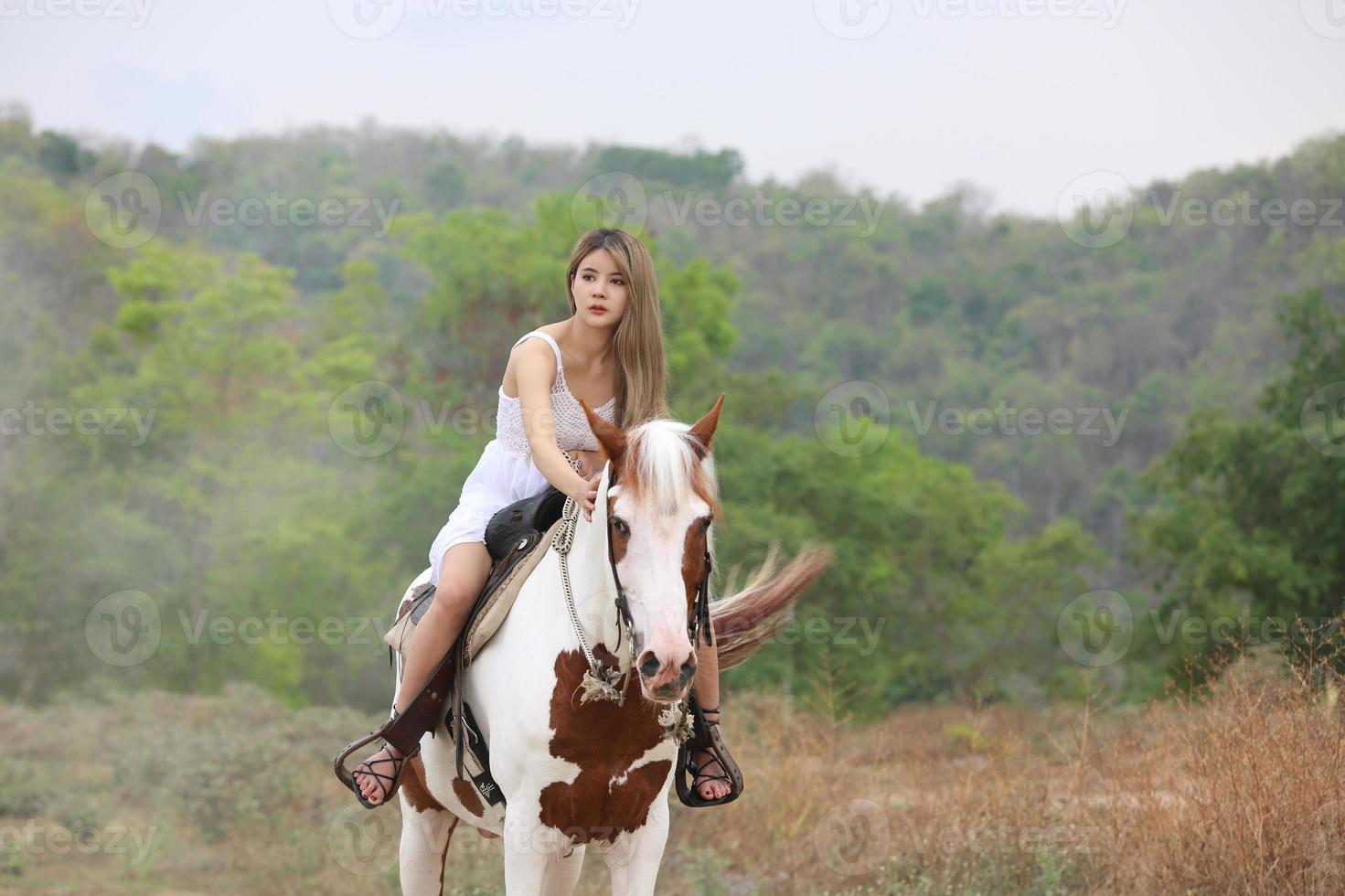 mujer joven con su caballo en la luz del atardecer. fotografía al aire libre con una modelo de moda. estado de ánimo de estilo de vida foto