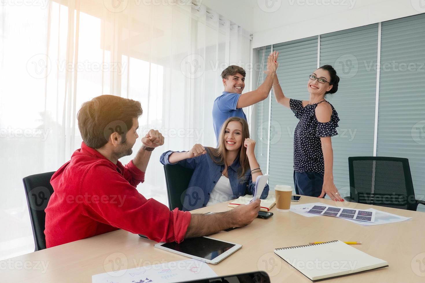 Diverse group of young business people discussing a work project while sitting together at a table in a modern office. coworking concept photo