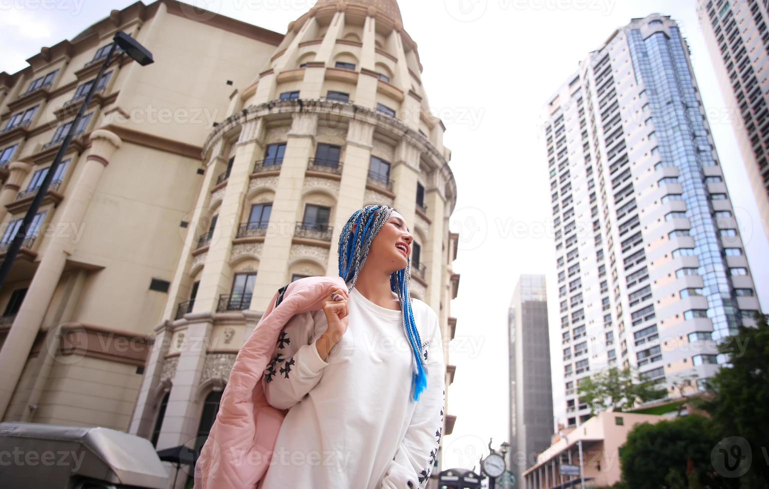 Portrait of Young girl with blue hair, teenage standing on street as urban life. photo