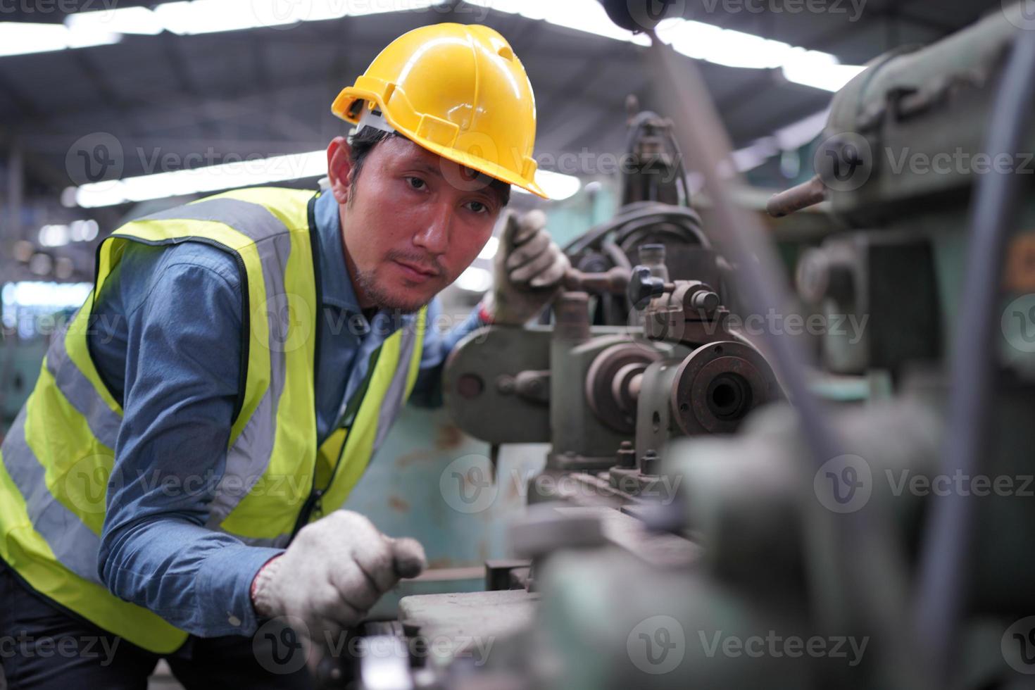 Maintenance Engineers is working in front of the automated CNC machinery repair on a maintenance checklist at the production line. photo