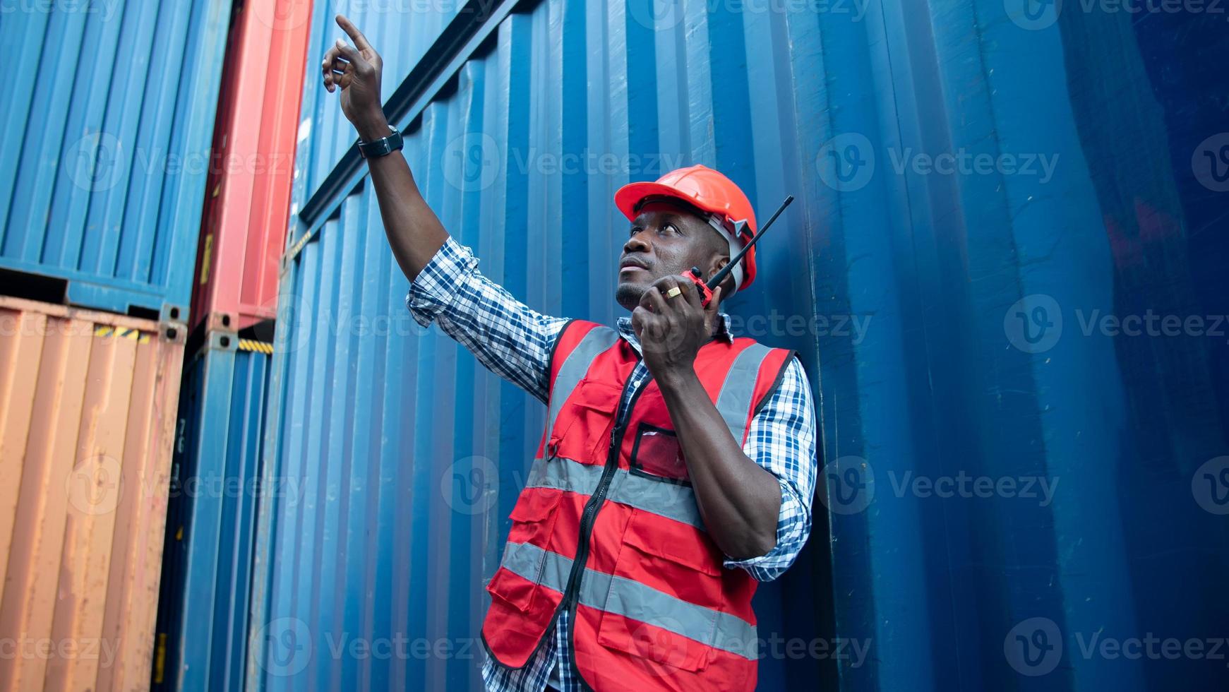 Engineer or supervisor checking and control loading Containers box from Cargo at harbor. Foreman control Industrial Container Cargo freight ship at industry. Transportation and logistic concept. photo