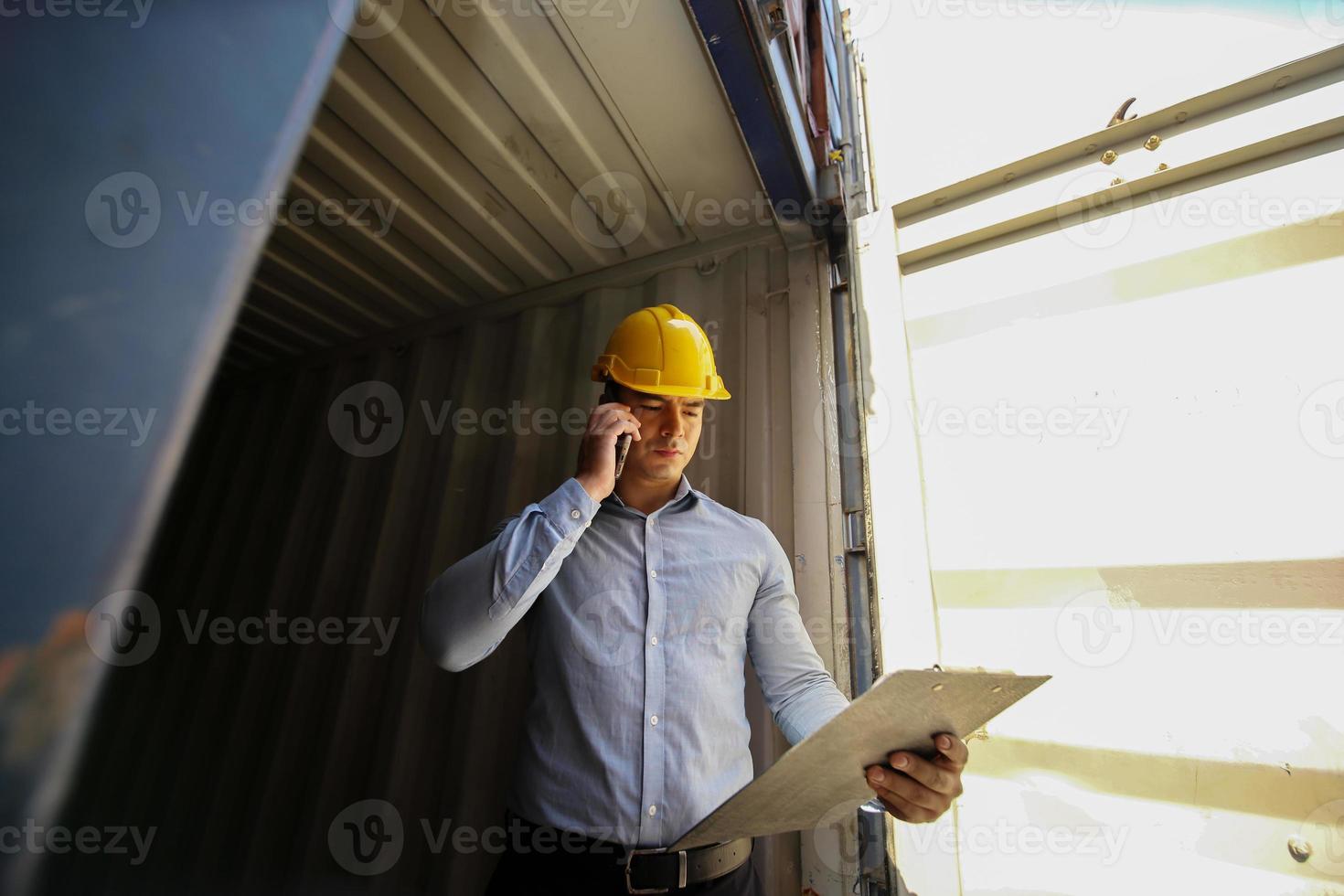 Foreman control loading Containers box from Cargo freight ship for import export. photo