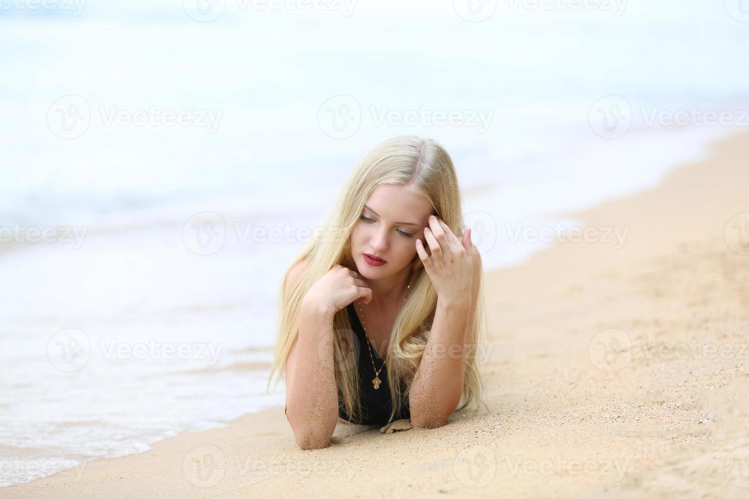 Beautiful blonde woman on black bikini enjoy summertime on the beach. photo