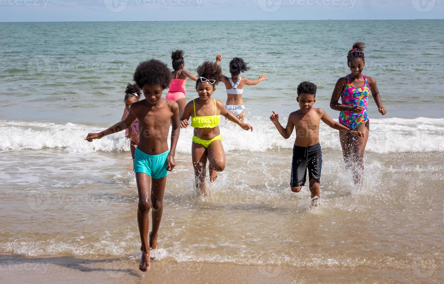 niños jugando corriendo en la arena en la playa foto