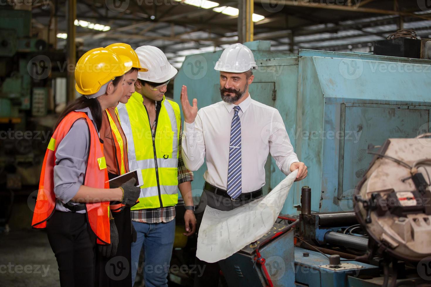 el capataz o el trabajo del trabajador en el sitio de la fábrica revisan la máquina o los productos en el sitio. ingeniero o técnico revisando material o máquina en planta. industrial y fábrica. foto