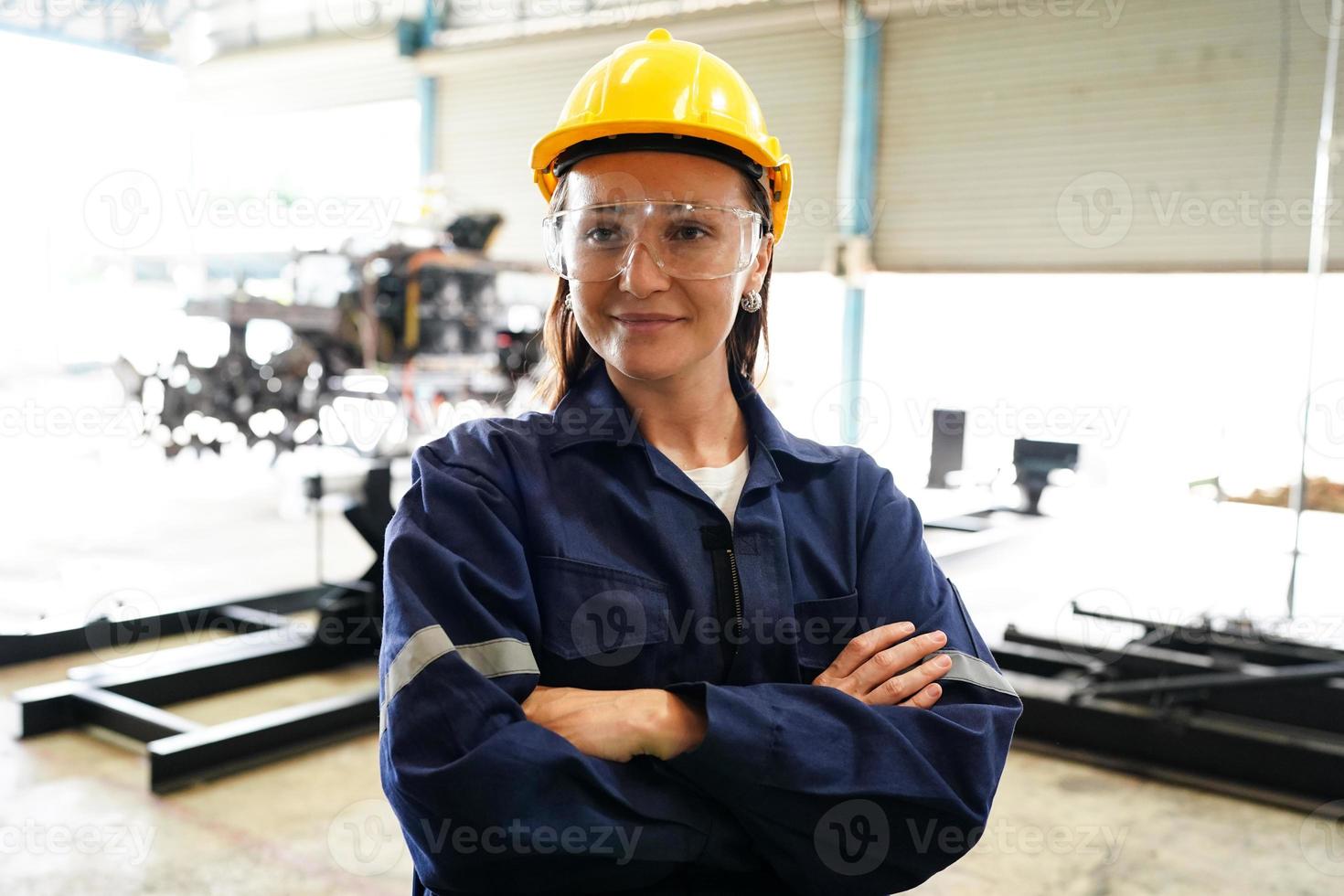 Industrial engineer or worker wearing a helmet while standing in a heavy industrial factory. The Maintenance looking of working at industrial machinery and check security system setup in factory. photo