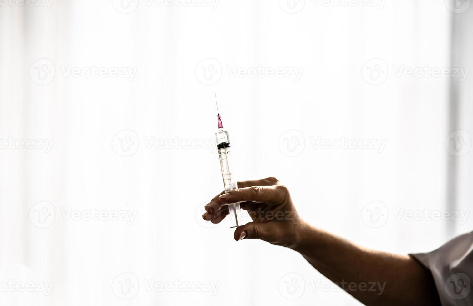 Doctor holding syringe on hand. photo