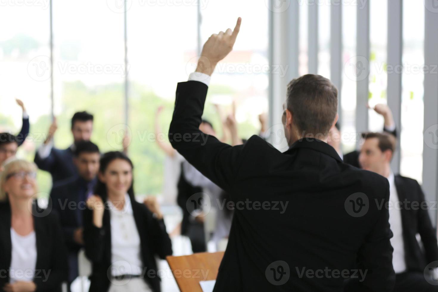 Speaker giving presentation in hall. Audience or conference hall. Rear view of unrecognized participants in audience. Scientific conference event, training photo