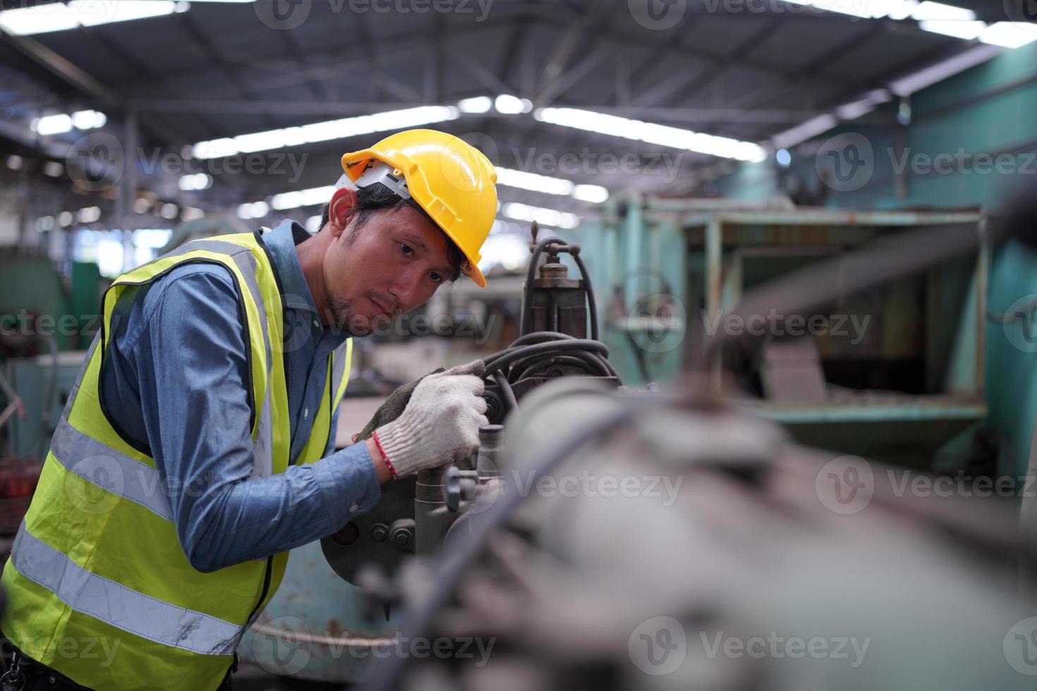 Maintenance Engineers is working in front of the automated CNC machinery repair on a maintenance checklist at the production line. photo
