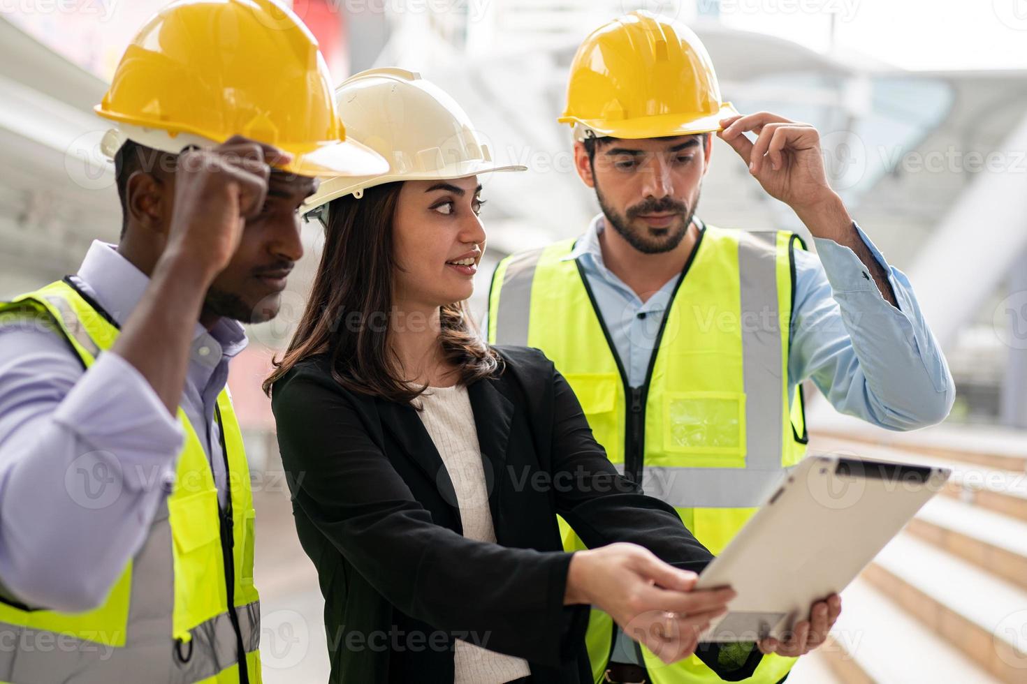 arquitecto, ingeniero civil y trabajador mirando planos y planos, discutiendo problemas en el sitio de construcción foto