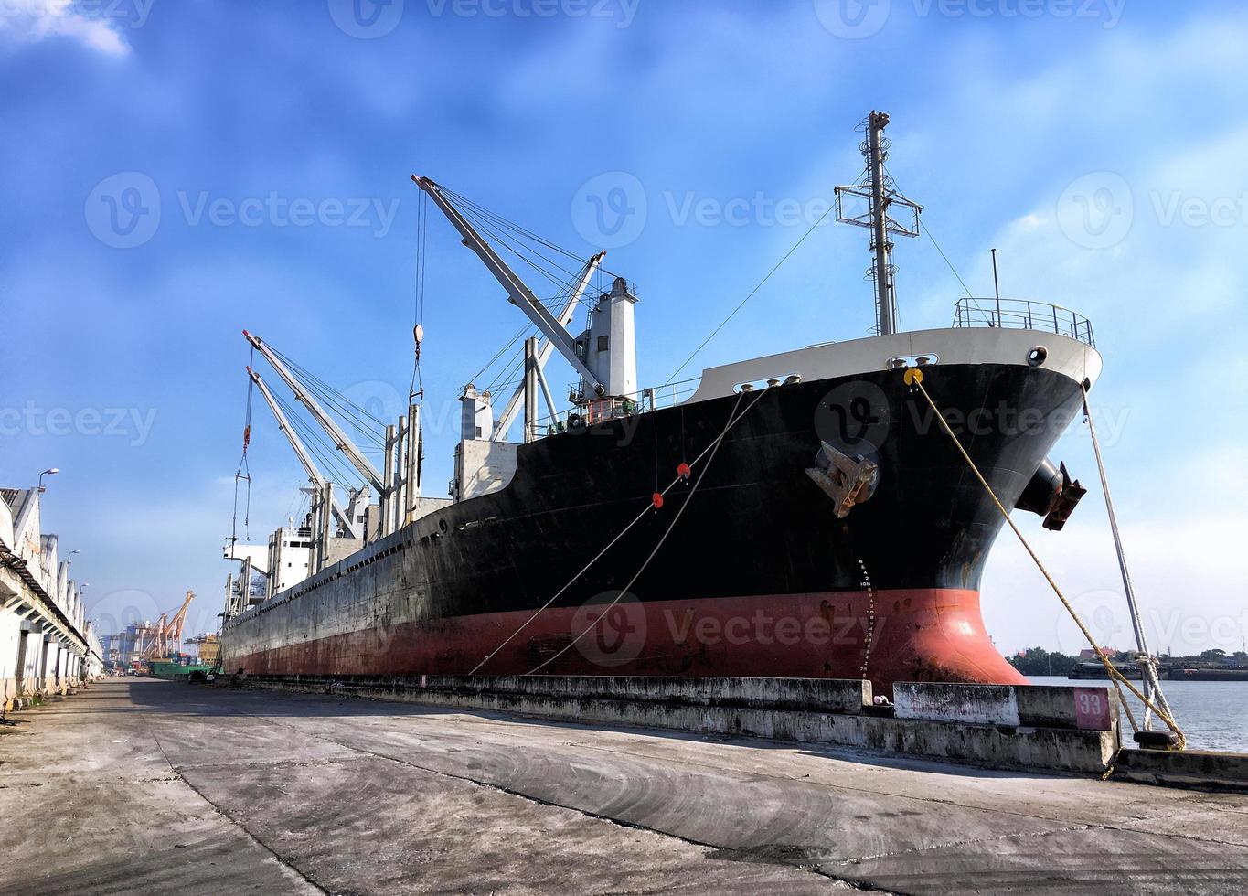 carga de contenedores en un buque de carga con grúa industrial. buque portacontenedores en empresa de logística comercial de importación y exportación. concepto de industria y transporte. foto