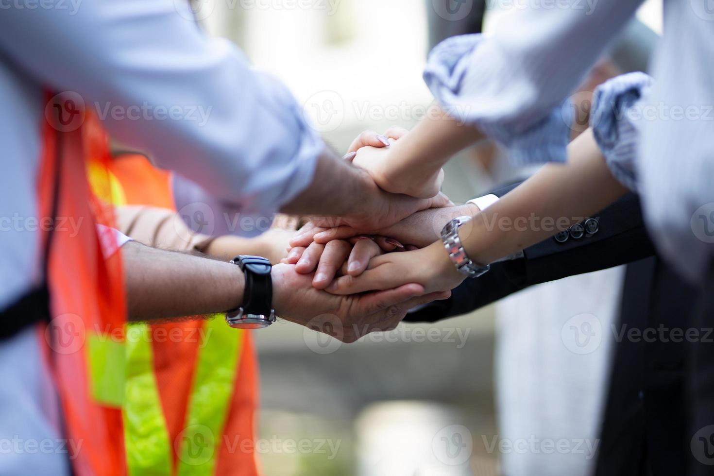 Stack of hands. Unity and teamwork concept. Close up top view of young business people putting their hands together photo