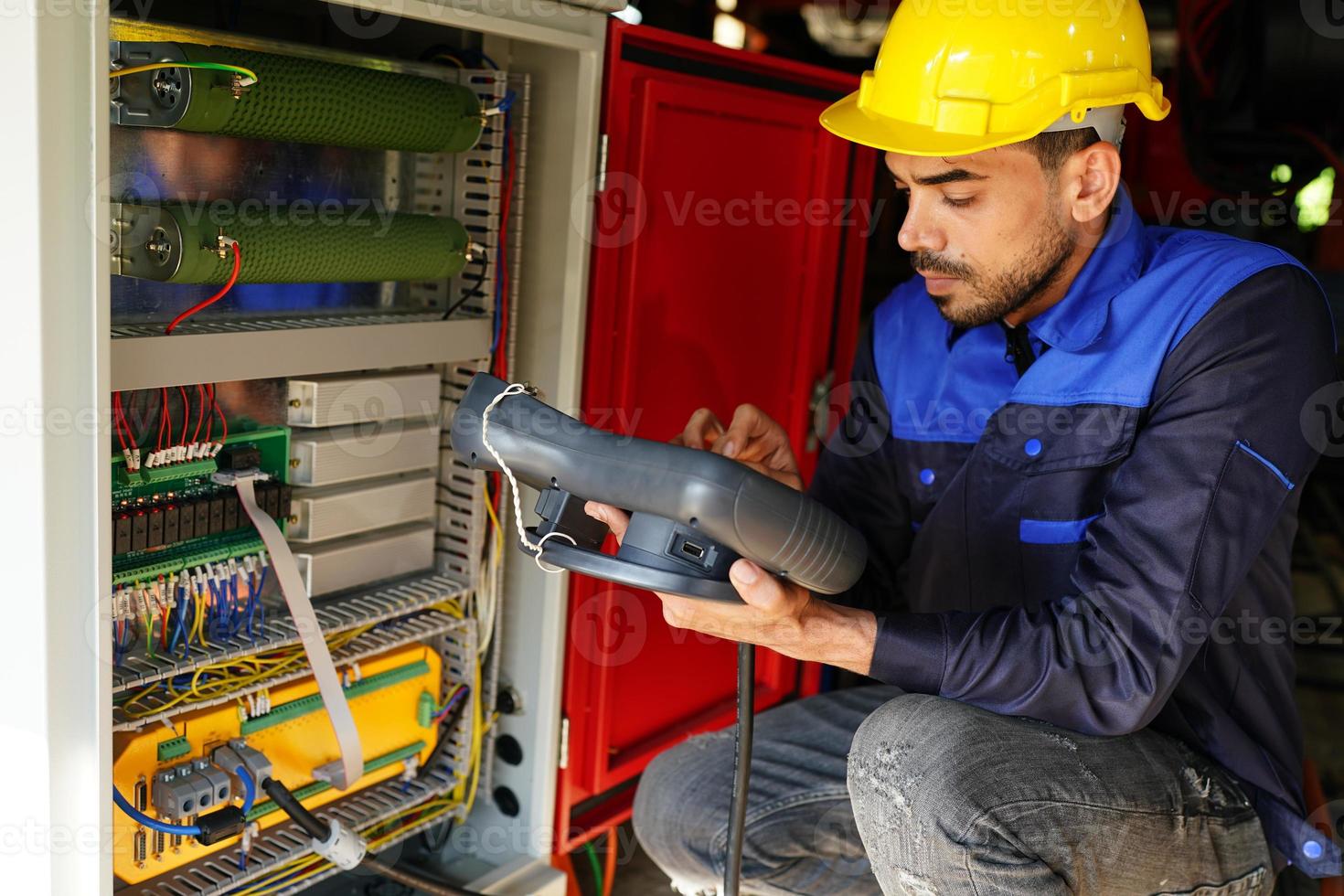 engineer checking control panel and teaching new Automatics robot arm and operating control machine in factory. photo