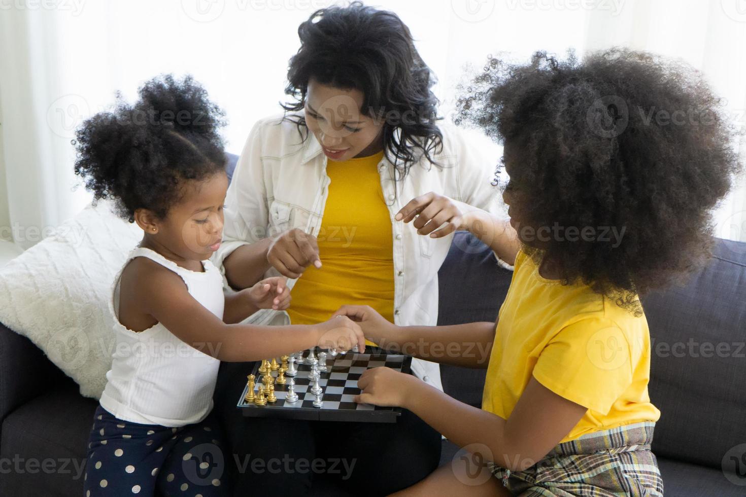 Portrait of happy young african American family with little kids sit relax on couch cuddling, smiling black parents rest on sofa hug preschooler children posing for picture at home together photo