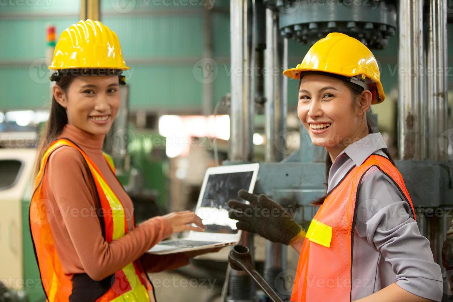 dos trabajadoras trabajan en el sitio de la fábrica revisando la máquina en la línea de productos o productos en el sitio. ingeniero o técnico revisando material o máquina en planta. industrial y fábrica. foto