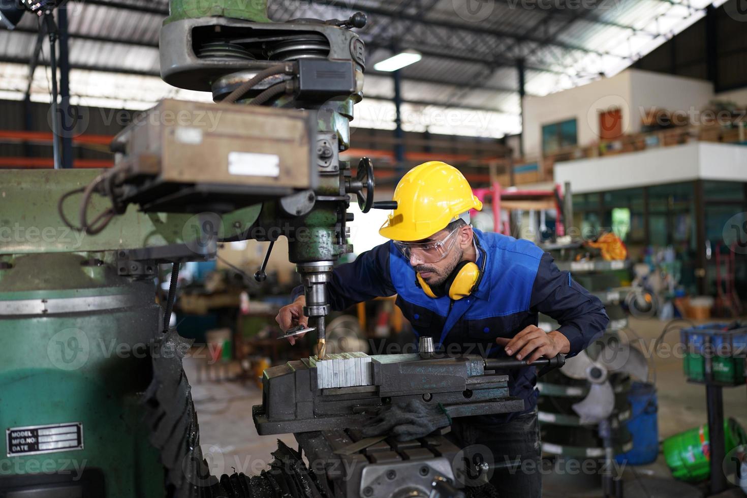 Professional industrial factory employee working with machine part, checking and testing industrial equipment and robot arms in large Electric electronics wire and cable manufacturing plant factory photo