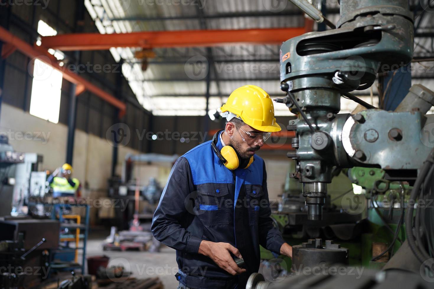 Professional industrial factory employee working with machine part, checking and testing industrial equipment and robot arms in large Electric electronics wire and cable manufacturing plant factory photo