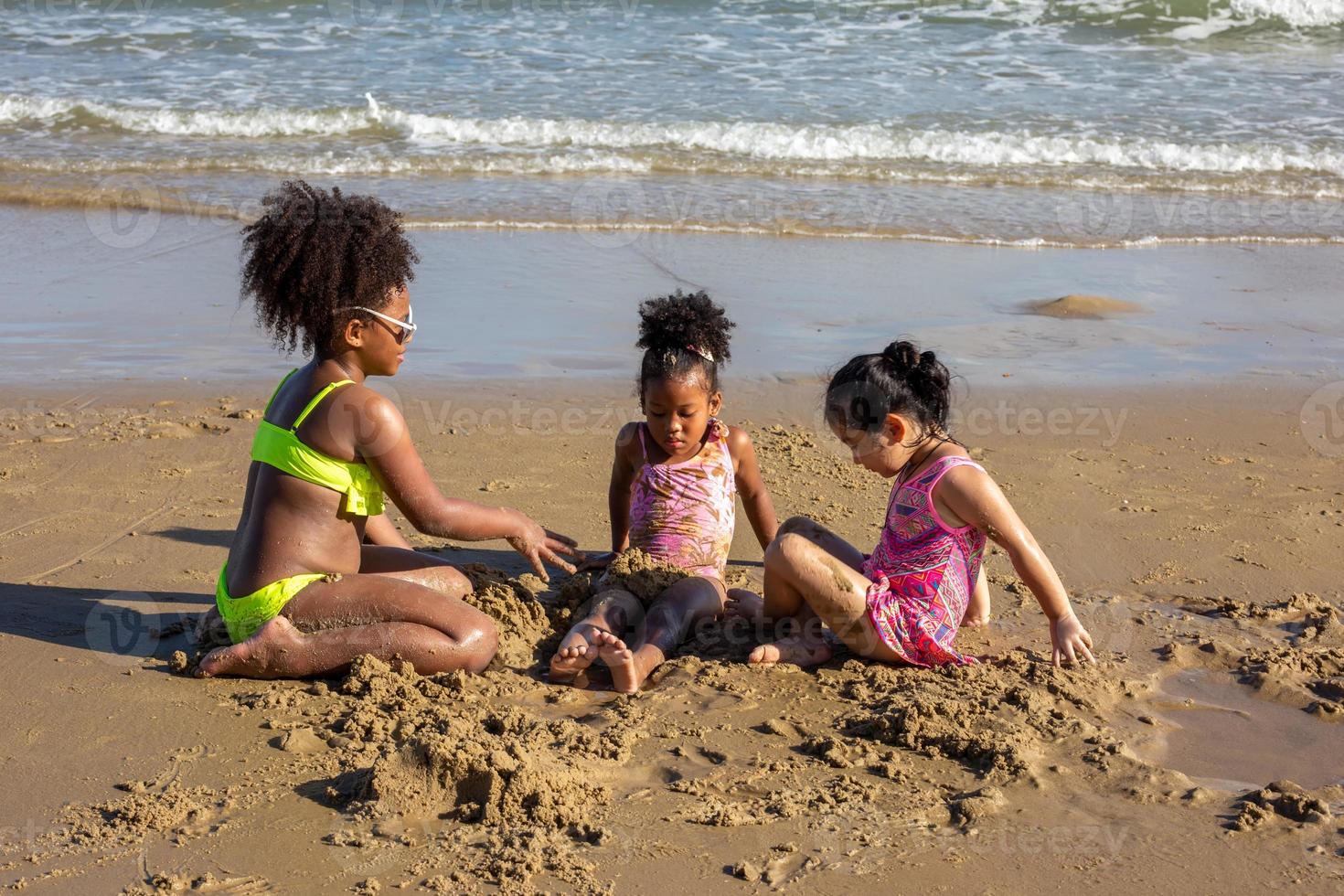 Kids playing running on sand at the beach photo