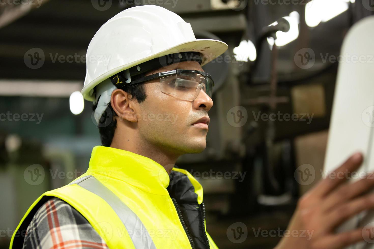 el capataz o el trabajo del trabajador en el sitio de la fábrica revisan la máquina o los productos en el sitio. ingeniero o técnico revisando material o máquina en planta. industrial y fábrica. foto