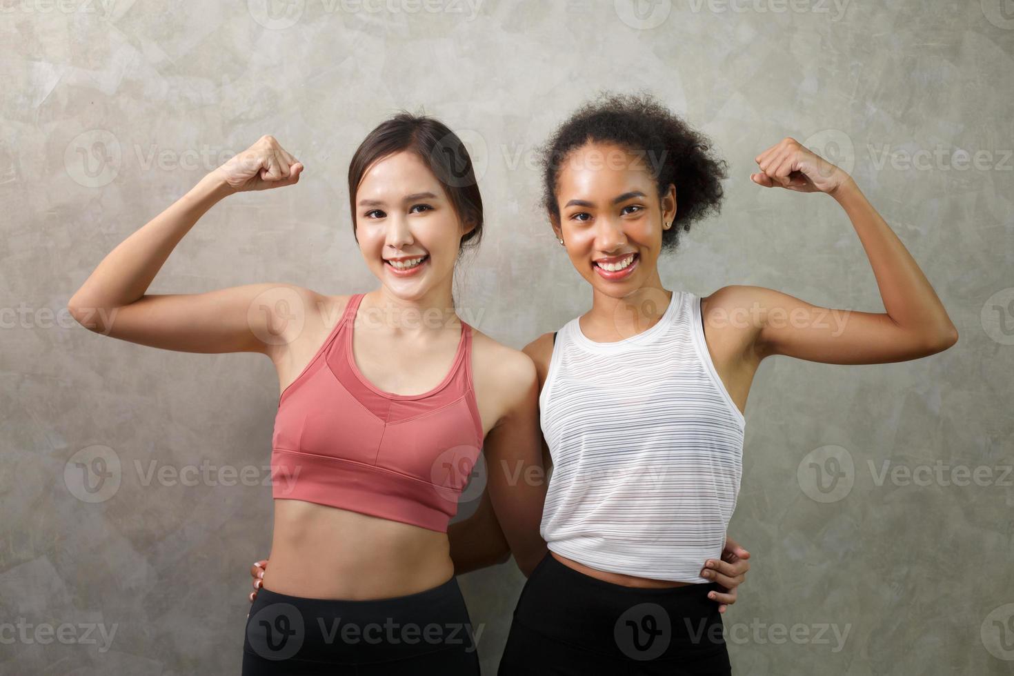 lifestyle portrait of two funny young friends on sportswear have fun and pretending faces. Home party mood. International Women's Day. Group of happy young women having smiling. photo