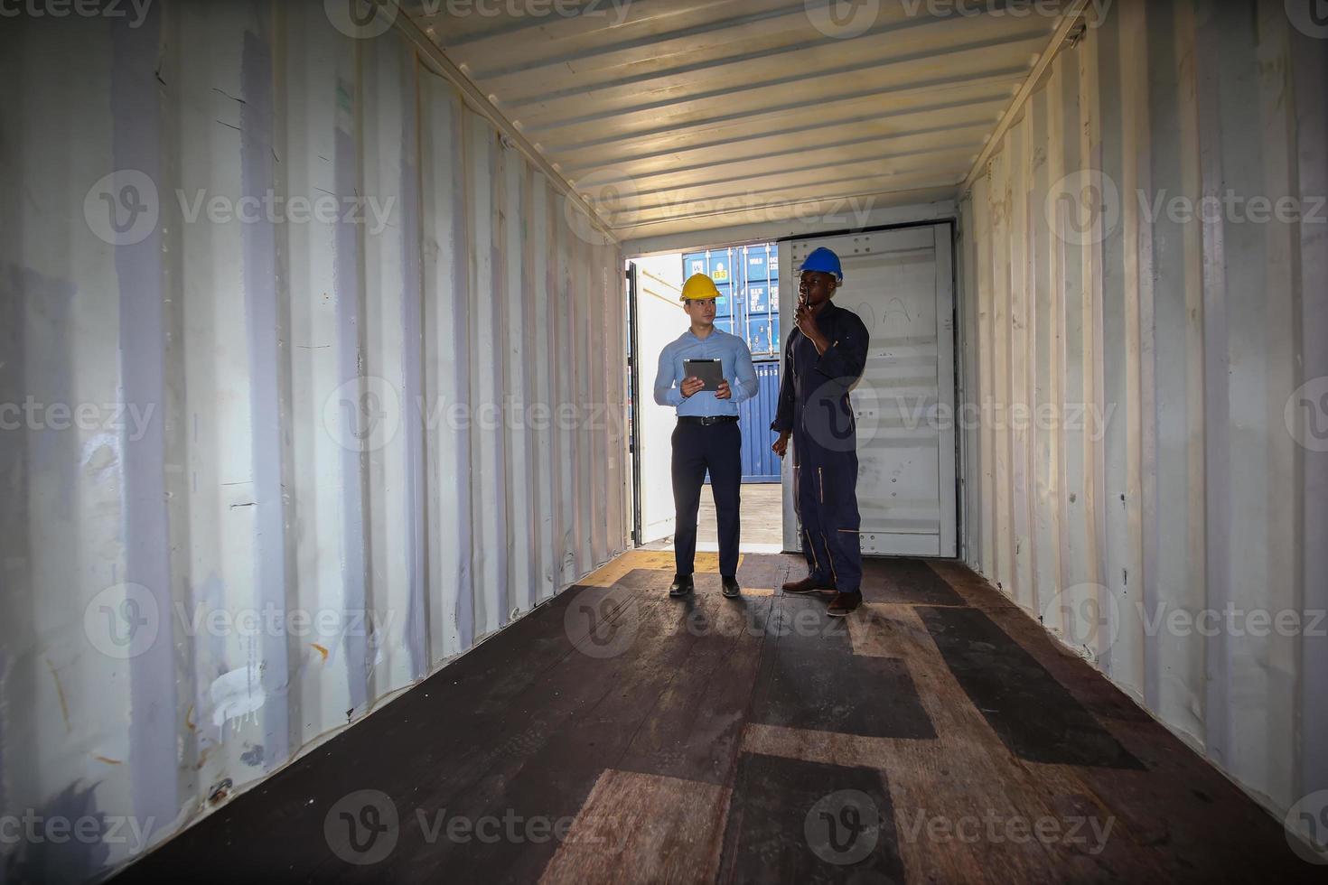 Foreman control loading Containers box from Cargo freight ship for import export. photo