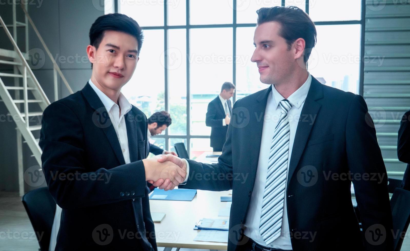 Successful business people standing together widen out showing strong relationship of worker community. A team of businessman and businesswoman expressing a strong group teamwork at the modern office. photo