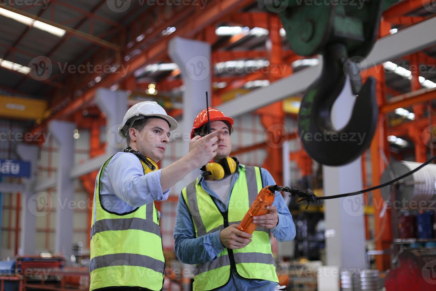 el capataz de los trabajadores de la industria o el trabajo de los trabajadores en el sitio de la fábrica revisan la máquina o los productos en el sitio. ingeniero o técnico revisando material o máquina en planta. industrial y fábrica. foto