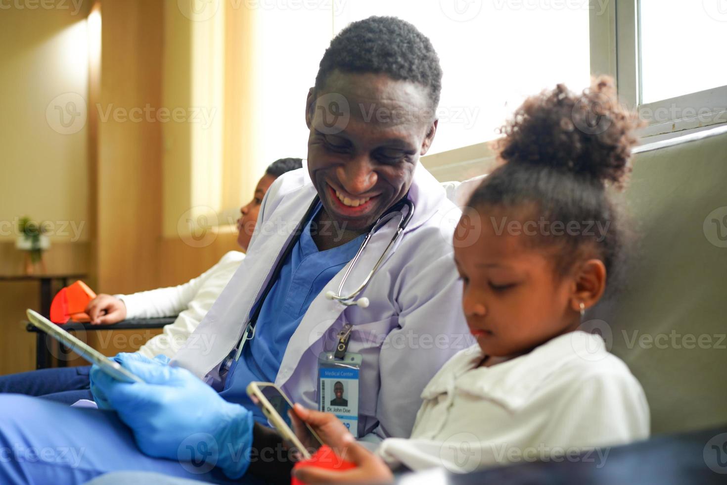 Black skin doctor checking up kid body in clinic. photo