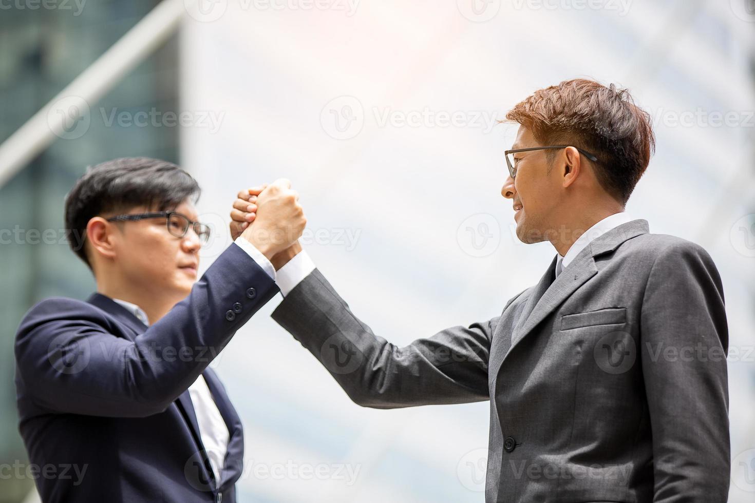 los empresarios exitosos que se unen se ensanchan mostrando una fuerte relación de comunidad de trabajadores. un equipo de hombres de negocios y mujeres de negocios que expresan un sólido trabajo en equipo en la oficina moderna. foto