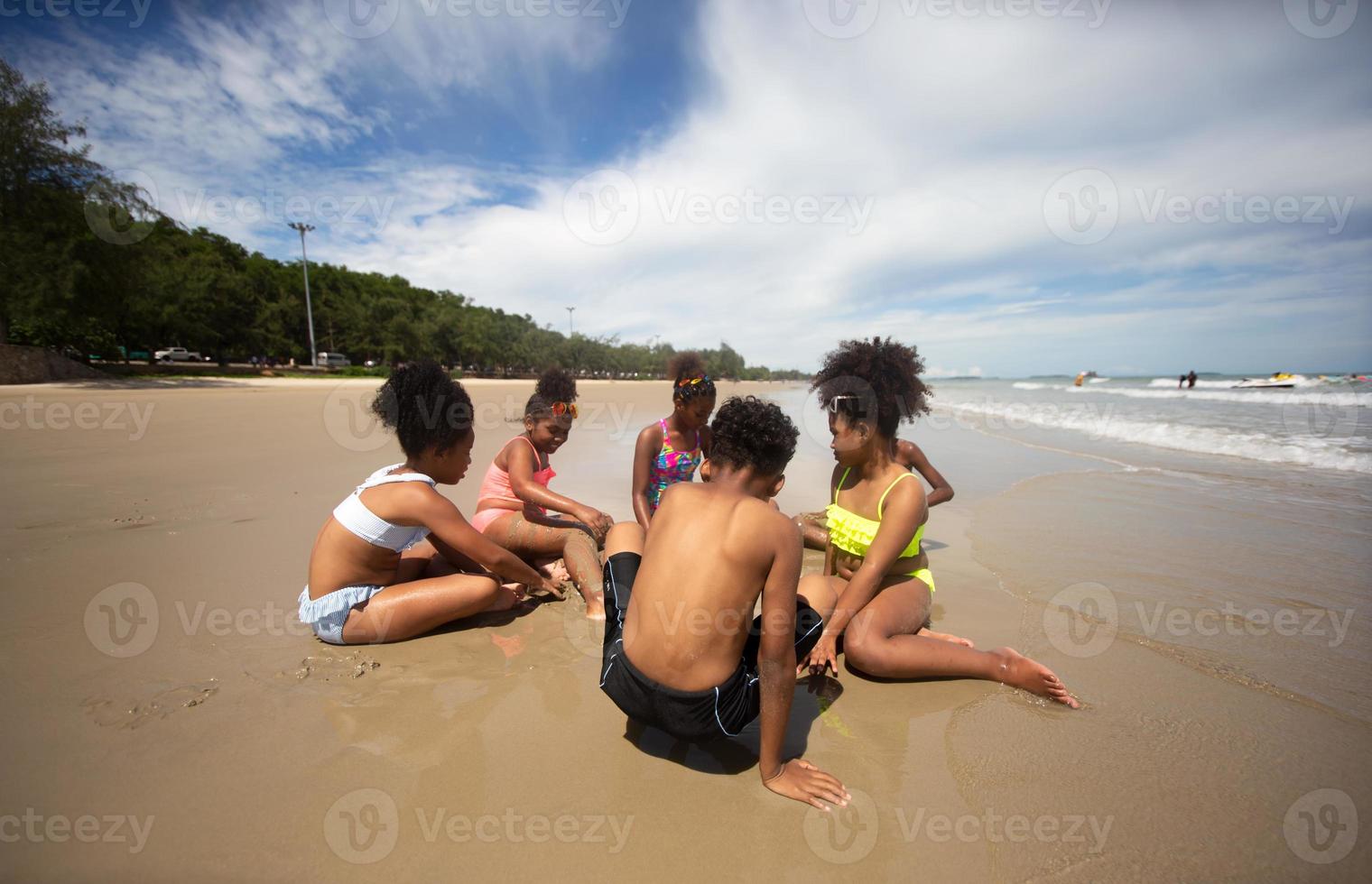 Kids playing running on sand at the beach photo